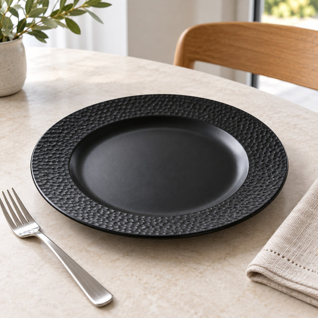 Black melamine serving plate beside a fork and folded napkin for a familiar sense of scale.