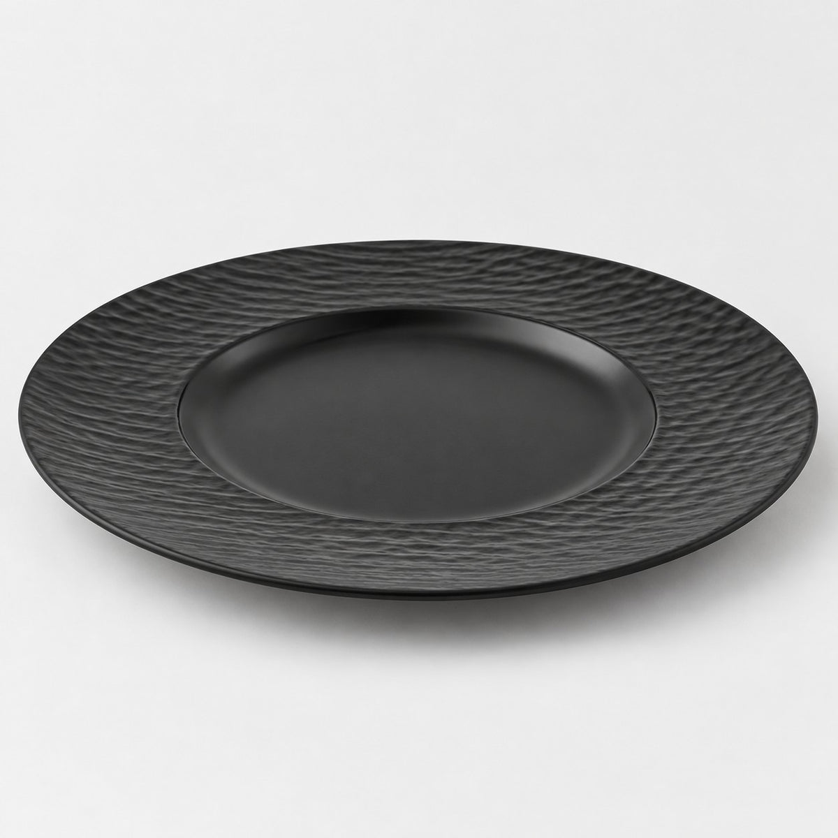 Black wide rim melamine plate with a shallow center well, shown alone on a light studio backdrop.
