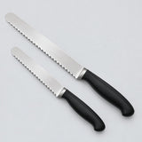 Two stainless steel serrated bread knives, one longer than the other, are shown on a pale backdrop.