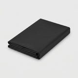 A folded black fabric sheet or blanket with a smooth matte finish, shown on a clean light gray background.