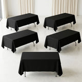 Five rectangular tables covered with black tablecloths stand in a bright room with cream curtains and pale flooring.