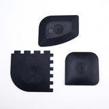 Three black plastic replacement parts with different shapes, displayed on a clean white background.