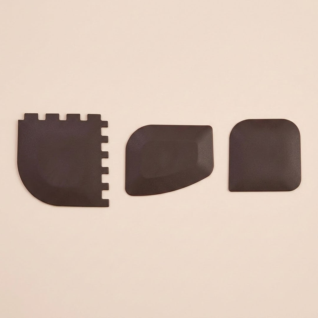 Three black textured replacement pads or covers arranged horizontally on a plain beige background.