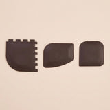 Three black textured replacement pads or covers arranged horizontally on a plain beige background.