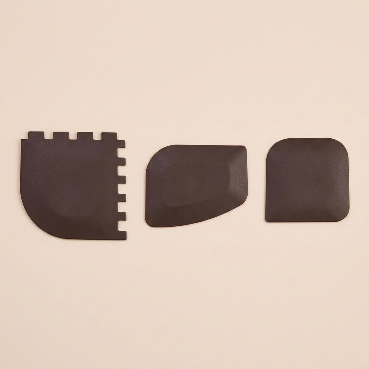 Three black textured replacement pads or covers arranged horizontally on a plain beige background.