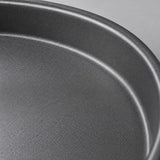 Close view of the pizza pan's fine matte nonstick interior and curved metal rim.