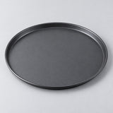 Twelve inch round charcoal nonstick pizza pan centered on a pale gray studio background.