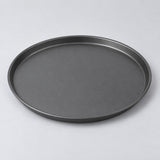 Eleven inch round charcoal nonstick pizza pan centered on a pale gray studio background.