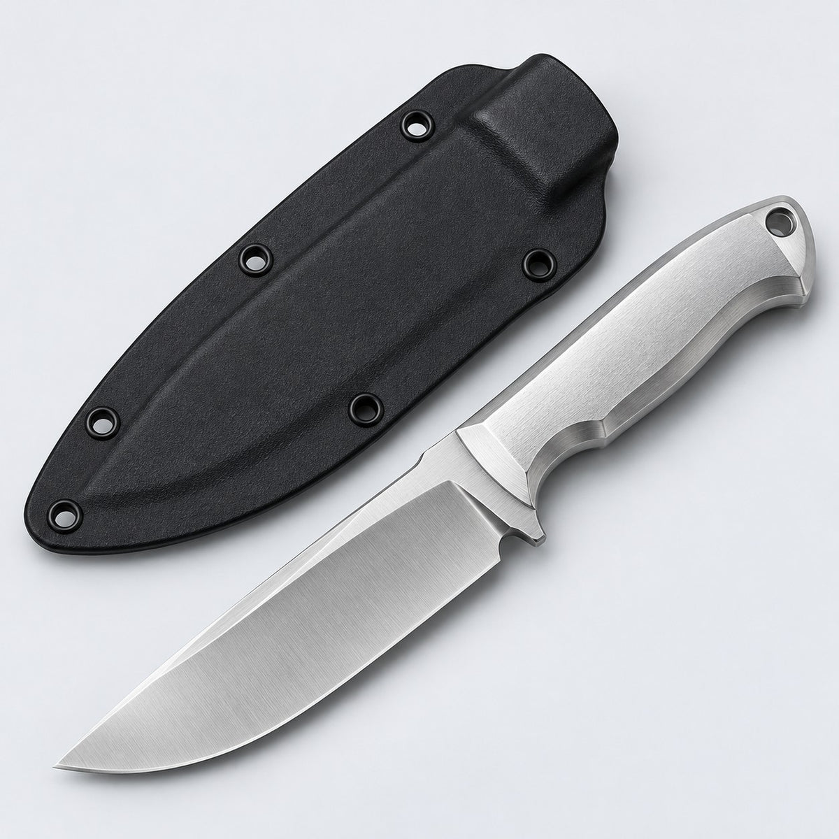 Silver steel fixed blade knife with its black sheath centered on a pale silver studio backdrop.
