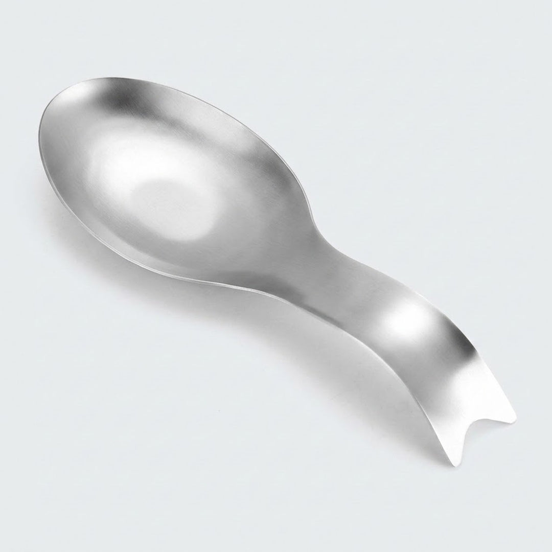 A polished stainless steel spoon with a unique, curved handle designed to look like a small knife or blade, shown on a light gray background.