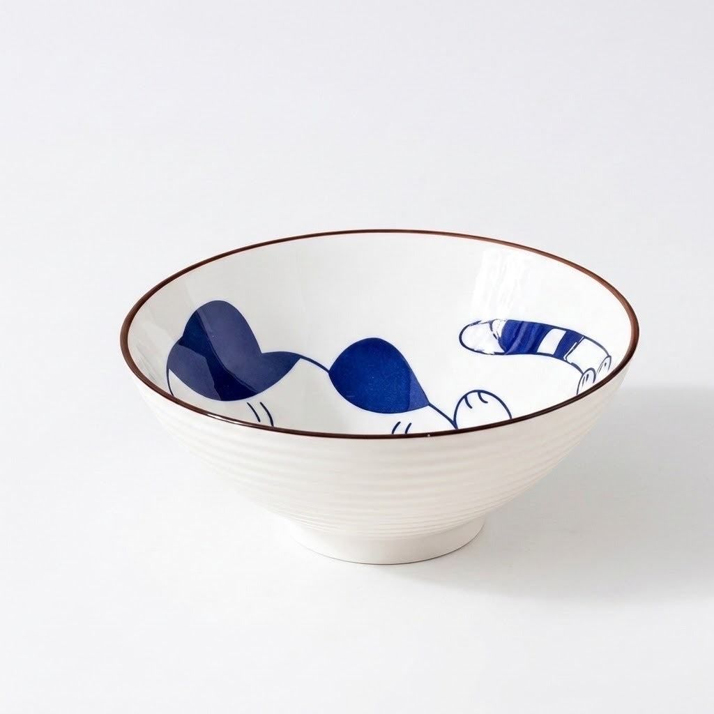 Empty white ceramic bowl with a blue cat illustration, brown rim, and ridged exterior sits against a white background.