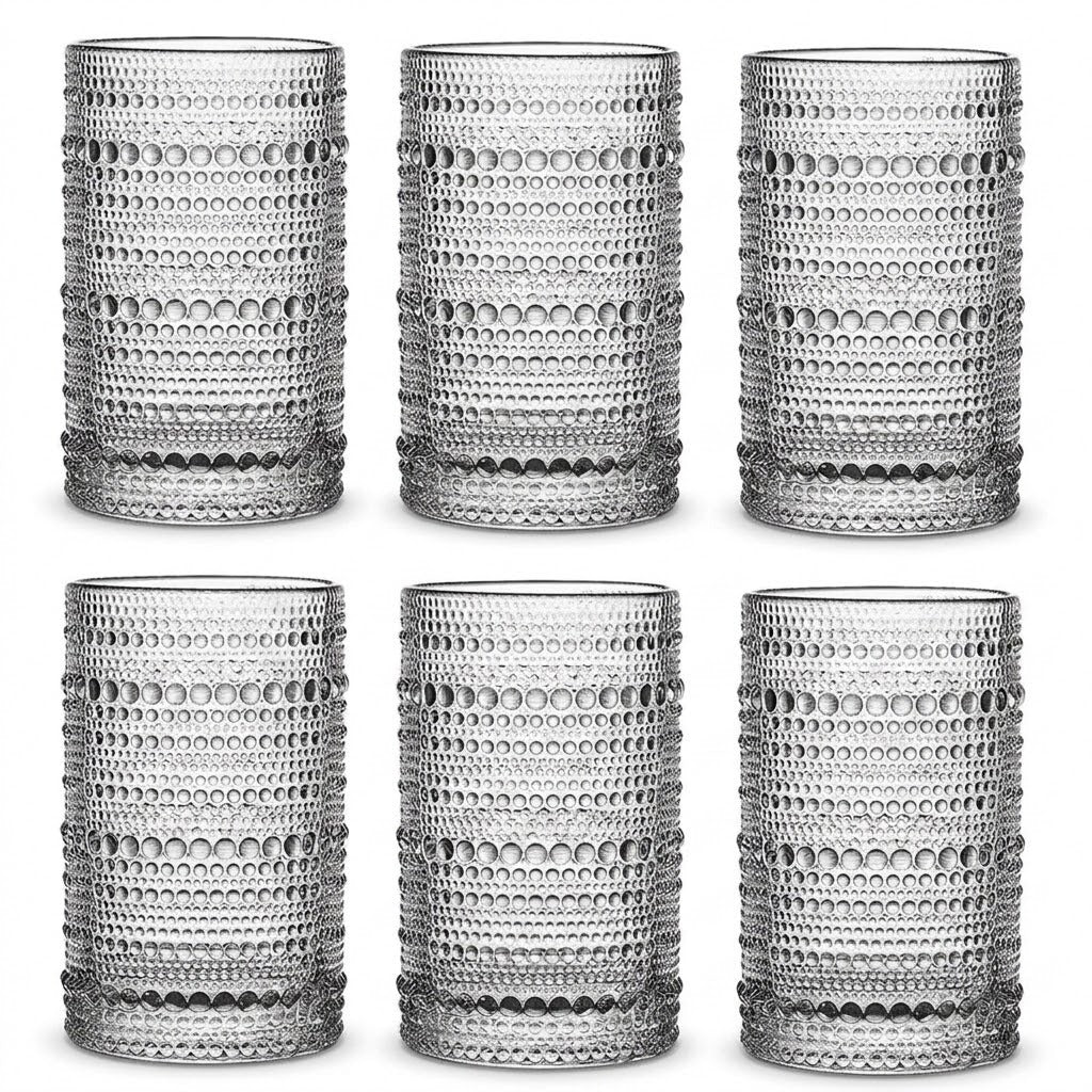 Six clear textured drinking glasses arranged in two rows of three on a white background. Each glass has a repeating circular dot pattern and a thick base.