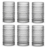 Six clear textured drinking glasses arranged in two rows of three on a white background. Each glass has a repeating circular dot pattern and a thick base.