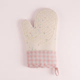 A quilted oven mitt in cream with a multicolor sprinkle pattern on the top half and a pink and white gingham check pattern on the bottom cuff, featuring a small pink loop at the wrist, shown on a light pink background.