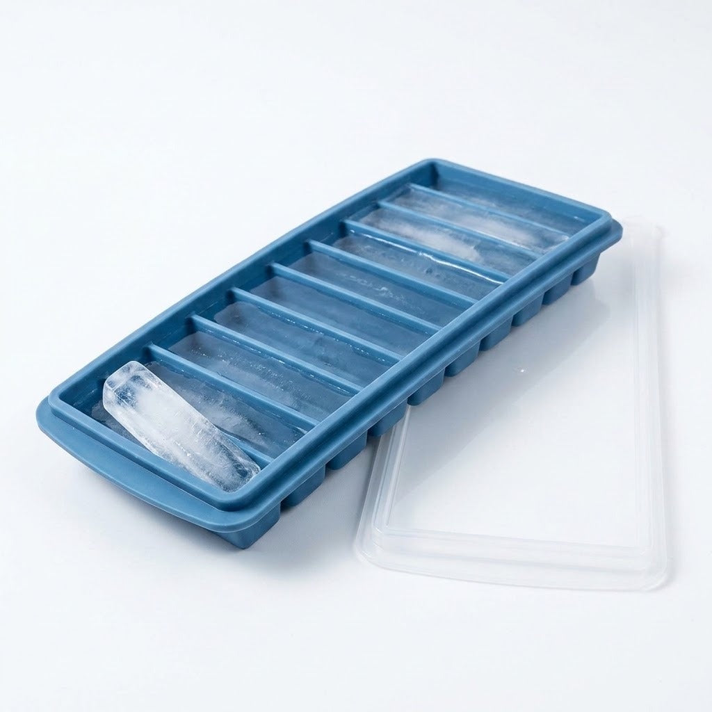 A blue tray holds long ice sticks, with one resting diagonally across a compartment and a translucent lid beside it.