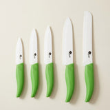 Five white-bladed knives with green handles, including one serrated knife, are arranged vertically by size on a cream background.