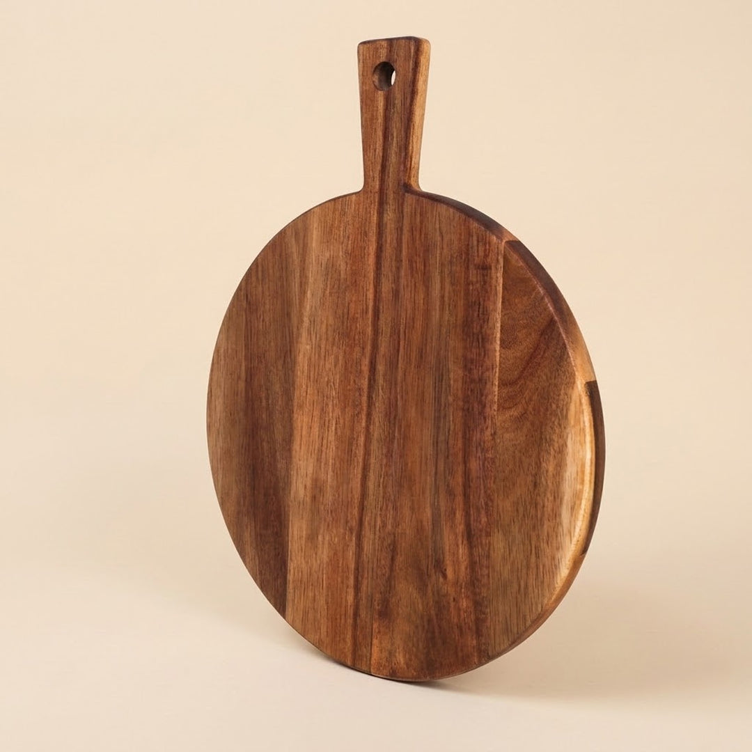 A round wooden serving board with a handle and a hanging hole, shown on a plain beige background.