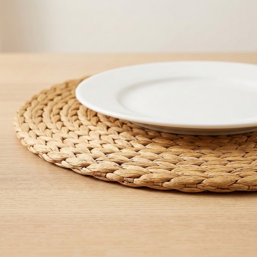A white plate rests on a tan woven placemat, with its braided edge visible against a light wooden table.