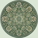 A circular decorative rug with an intricate mandala and floral pattern in shades of dark green and beige, shown flat against a light green background.