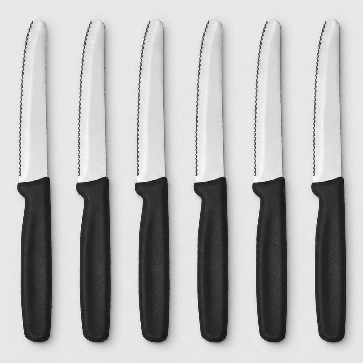 Six serrated knives with silver blades and black handles arranged vertically side by side on a light grey background.