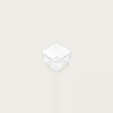 Small clear square organizer tray with rounded corners and circular base details sits centered on an off-white background.