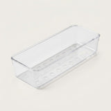 Long clear rectangular organizer tray with circular base details and rounded corners rests diagonally on an off-white background.