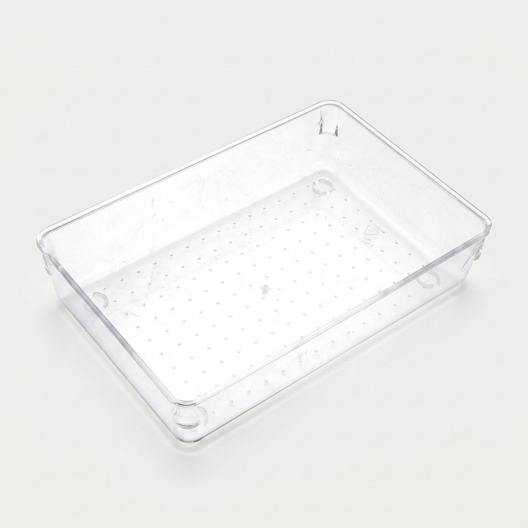 Wide clear rectangular organizer tray with a dotted base, smooth sides, and rounded corners sits on an off-white background.