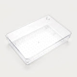 Wide clear rectangular organizer tray with a dotted base, smooth sides, and rounded corners sits on an off-white background.