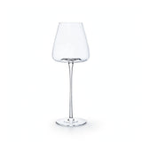 A single empty clear wine glass with a tapered bowl, slender stem, and round base stands against a white background.