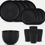 Black dinnerware is arranged against a white background with overlapping large and small plates, four stacked bowls, and four tall cups.