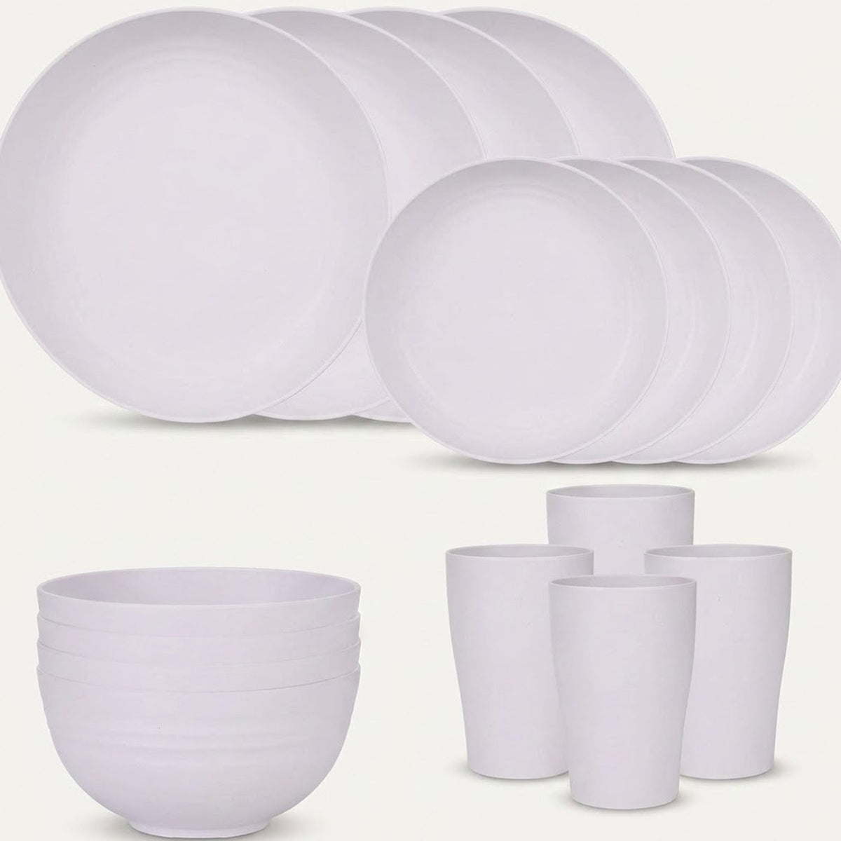 White dinnerware is arranged against a pale background with overlapping large and small plates, stacked bowls, and four tall cups.