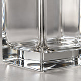A macro view shows the smooth clear glass corner and thick polished base of the square decanter.