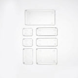 Six clear rectangular plastic trays of different sizes arranged in a grid on a white background.