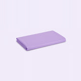 A folded sheet in a solid light purple or lavender color, displayed on a clean, light lavender-white background.