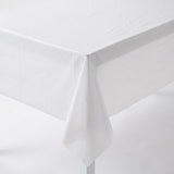 Close-up of a white plastic tablecloth draped over a rectangular table corner against a white background.