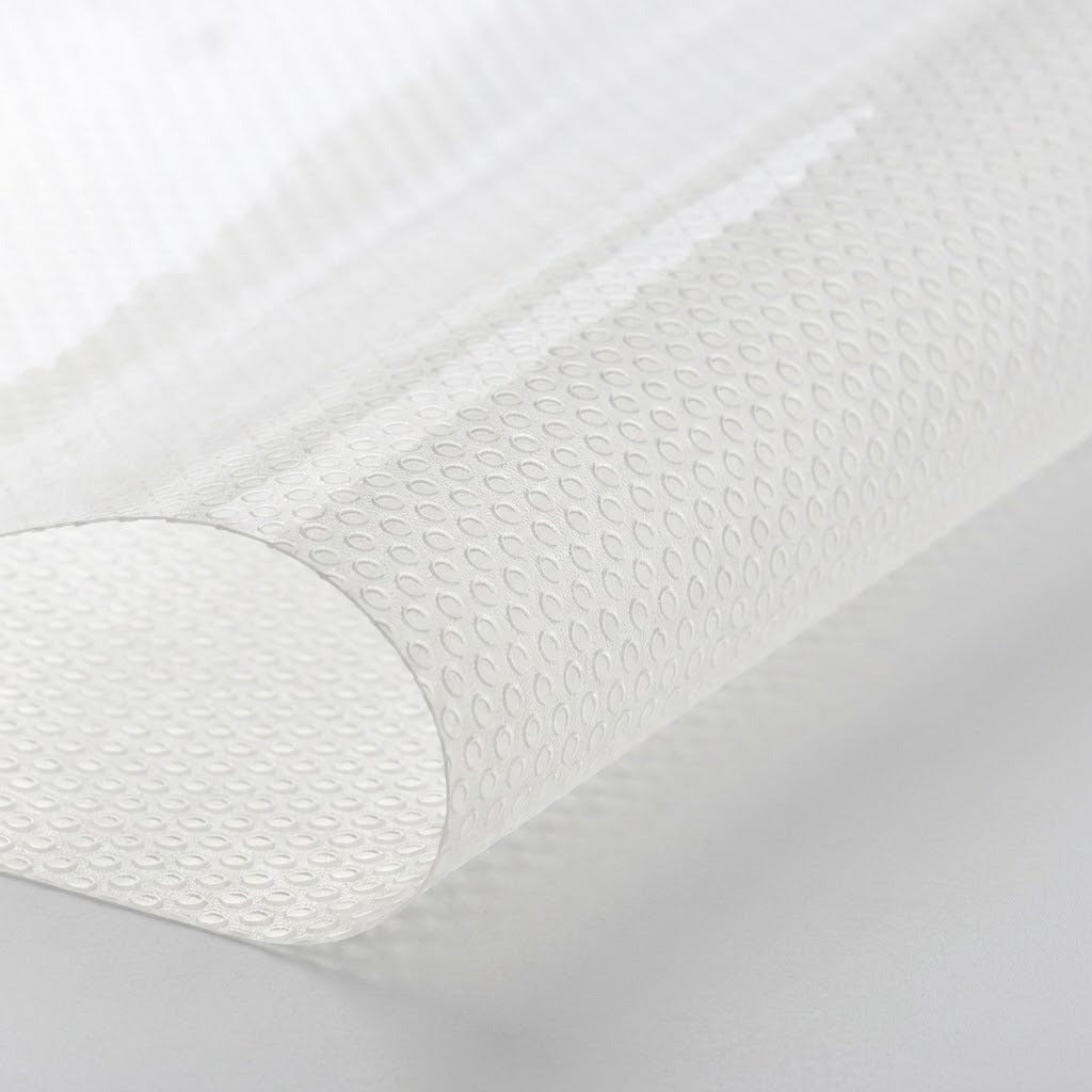 A close-up of a white textured sheet or mat with a raised repeating oval pattern, shown rolled or curved against a light gray background.