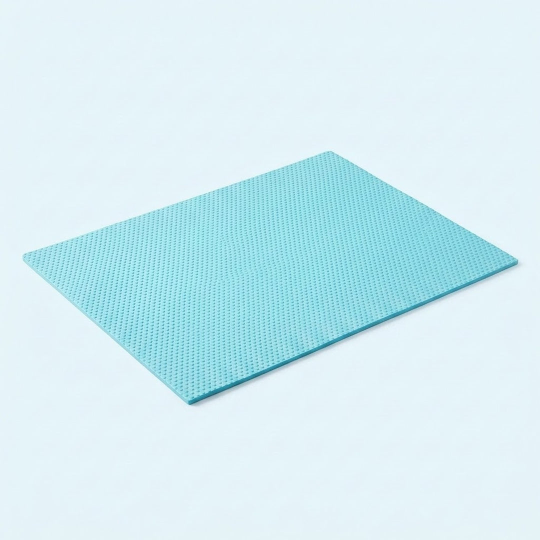 A square light blue textured mat with a fine grid pattern, shown at an angle on a clean white background.