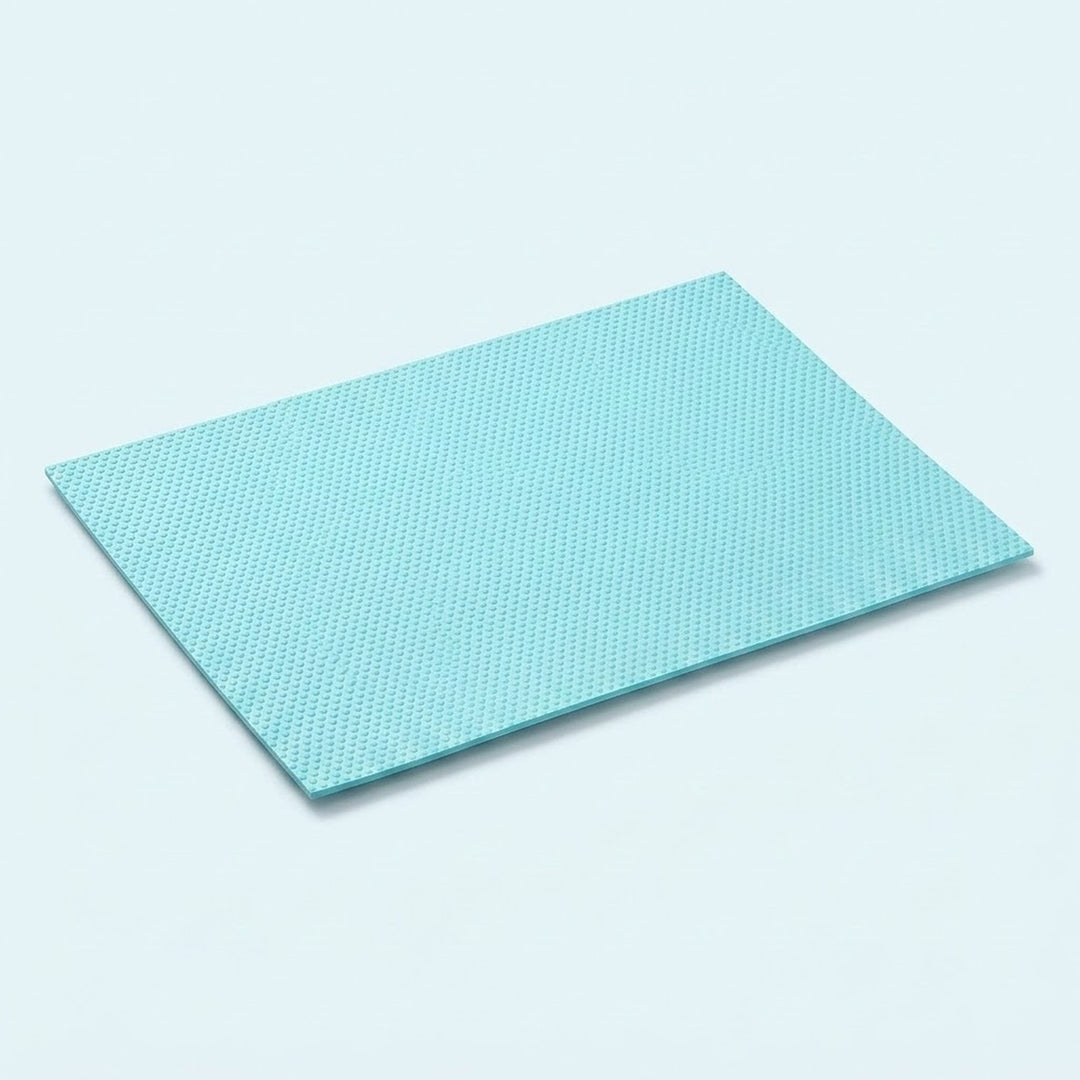 A rectangular light blue textured mat with a fine grid pattern, shown at an angle on a light blue background.