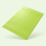 A lime green textured rectangular sheet or mat shown floating at an angle against a very light off-white background.