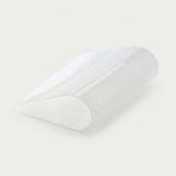A translucent white textured silicone or plastic wedge-shaped insert, shown partially rolled on a clean off-white background.