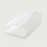 A roll of textured white adhesive tape, partially unrolled to show its patterned surface, set against a solid light gray background.