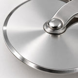 Macro view of the pizza cutter wheel's smooth polished stainless steel blade edge.