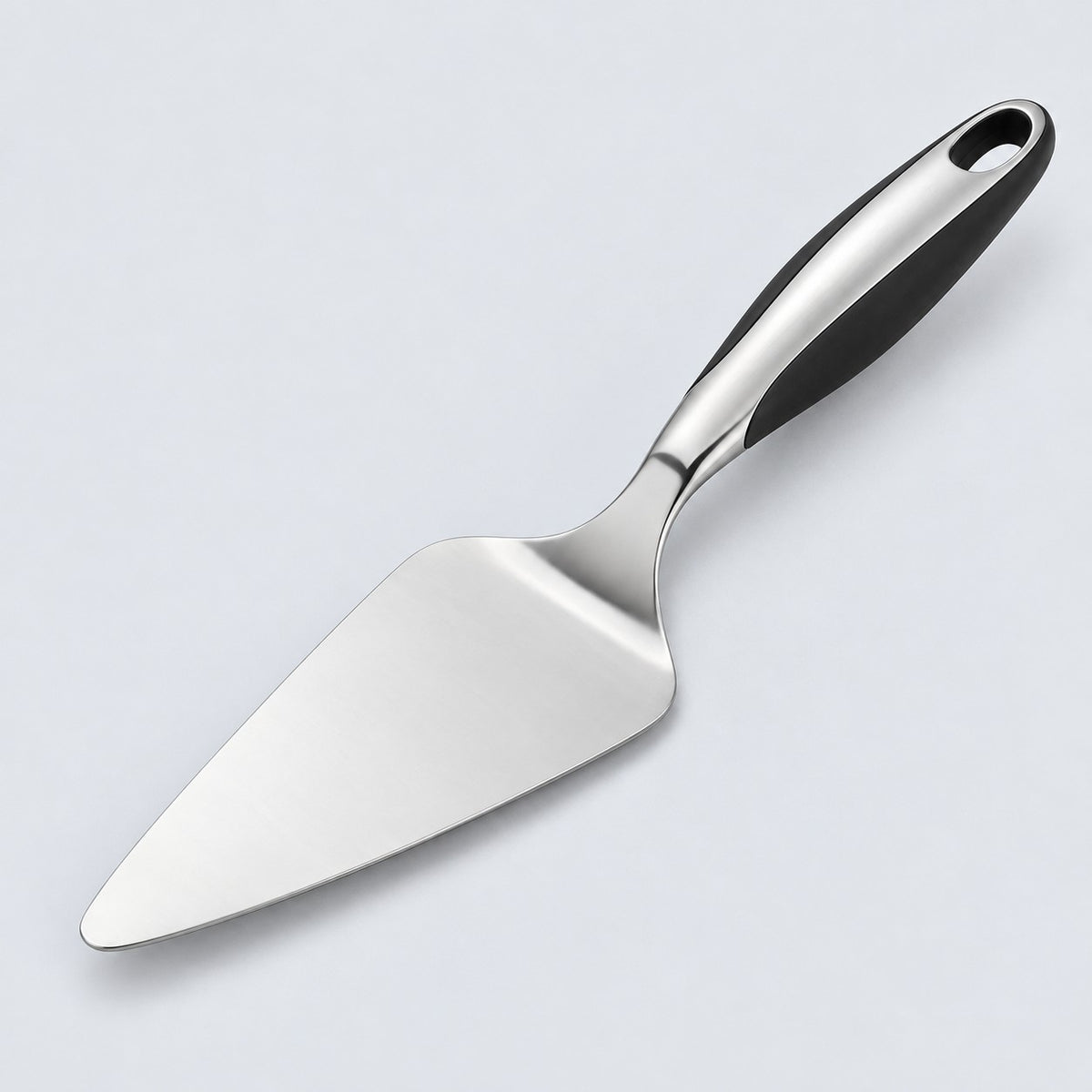 Stainless steel pizza server with triangular blade and black handle on a pale studio background.