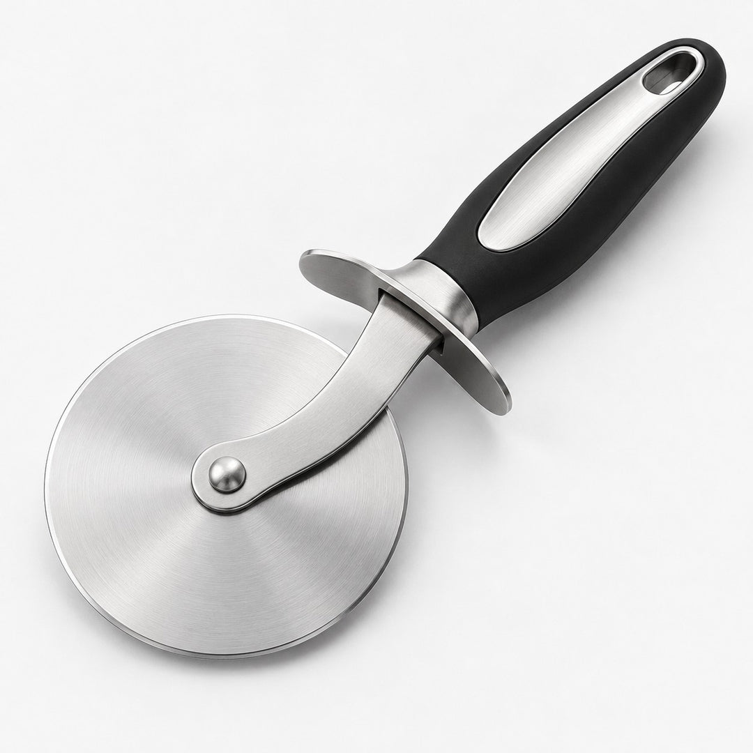 Pizza cutter wheel with round stainless steel blade, finger guard and black handle on a pale backdrop.