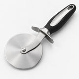 Pizza cutter wheel with round stainless steel blade, finger guard and black handle on a pale backdrop.