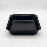 A black rectangular plastic tray with raised edges, photographed from above on a light gray studio background.