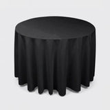 A round black tablecloth draped over a round table, shown against a plain light gray studio background.