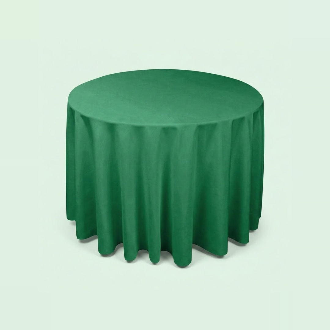 A round green tablecloth draped over a circular table, shown against a plain light mint-green background.