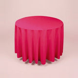 A round table covered with a bright pink tablecloth, shown against a plain light beige studio background.