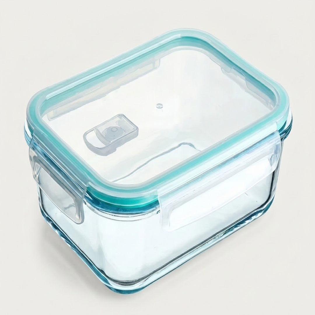 A rectangular glass food storage container with a clear lid and a light blue silicone seal, shown on a plain light beige background.